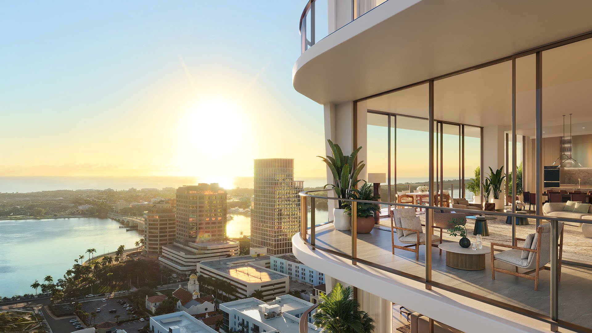 Sunset view from a curved glass balcony looking into an elegant residence at Banyan Tree Residences in West Palm Beach, featuring luxury and ultra luxury condos with dramatic waterfront exposure and expansive outdoor living space.