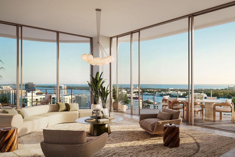 Wraparound great room with curved seating, floor-to-ceiling glass, and a terrace overlooking the water at Banyan Tree Residences in West Palm Beach, highlighting luxury and ultra luxury condos with expansive indoor outdoor living.