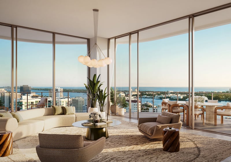 Wraparound great room with curved seating, floor-to-ceiling glass, and a terrace overlooking the water at Banyan Tree Residences in West Palm Beach, highlighting luxury and ultra luxury condos with expansive indoor outdoor living.