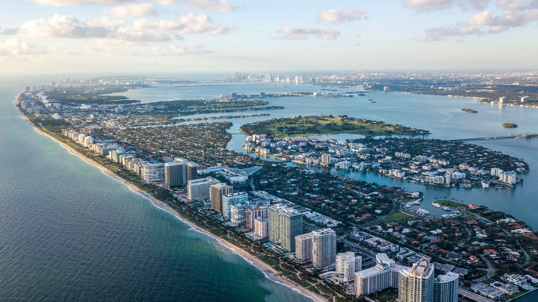 Bay Harbor Islands, Miami aerial coastal view of turquoise waterways and islands, highlighting luxury and ultra luxury condos; prime area for preconstruction and resale.