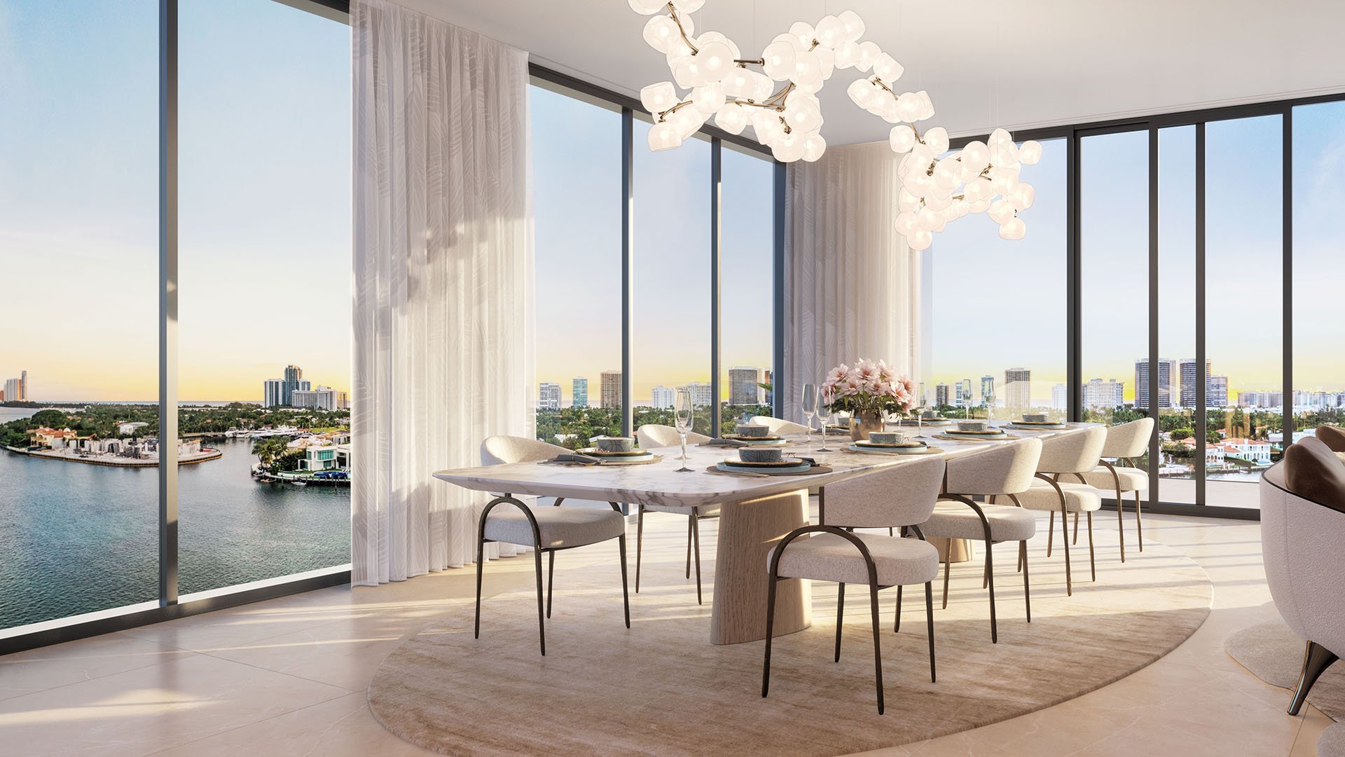 Bay Harbor Towers, Bay Harbor Islands, Florida waterfront dining room with marble table, designer chandelier and floor-to-ceiling windows overlooking the bay and skyline, showcasing luxury and ultra luxury preconstruction condos.