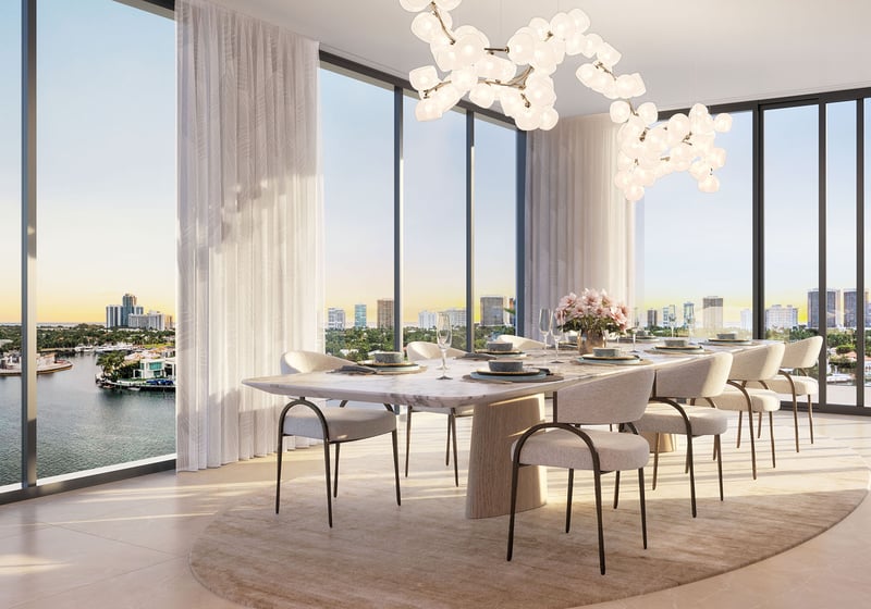 Bay Harbor Towers, Bay Harbor Islands, Florida waterfront dining room with marble table, designer chandelier and floor-to-ceiling windows overlooking the bay and skyline, showcasing luxury and ultra luxury preconstruction condos.
