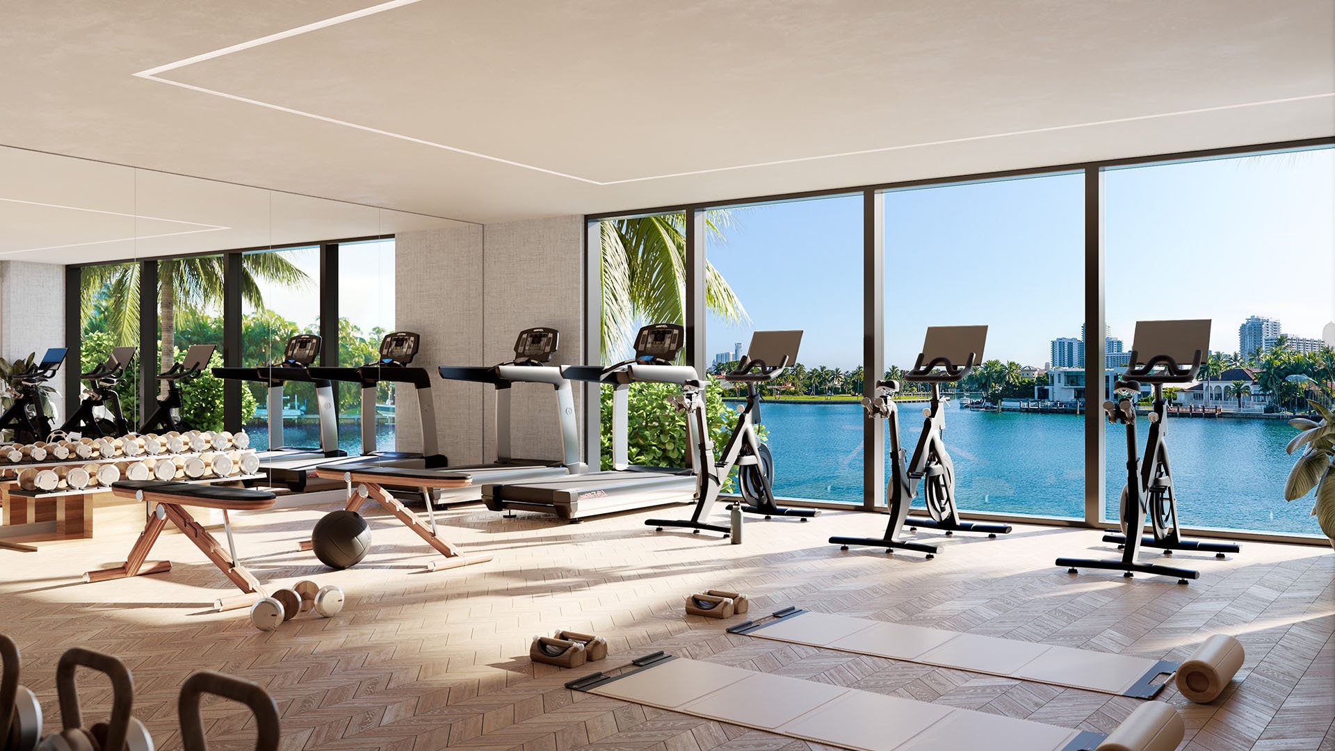 Bay Harbor Towers Bay Harbor Islands, Florida fitness center with treadmills, bikes and free weights facing floor-to-ceiling windows over the bay, featuring luxury and ultra luxury preconstruction condos amenities.