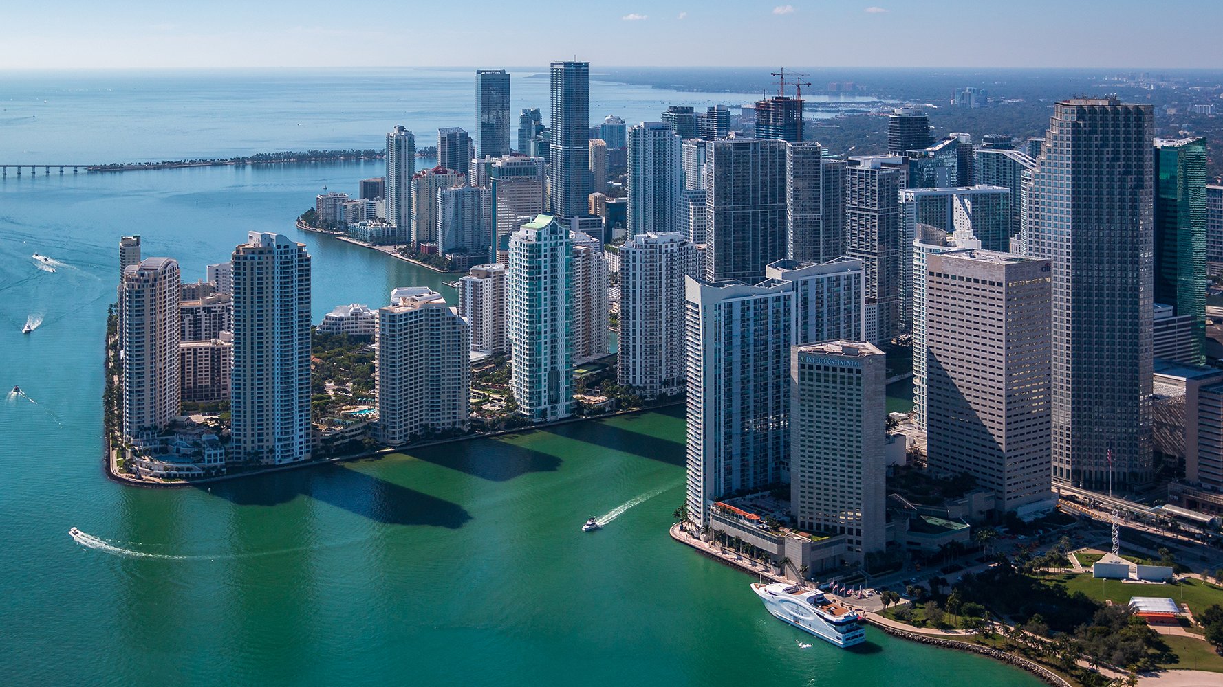 Aerial of Brickell, Miami skyline over Biscayne Bay—dense cluster of luxury and ultra luxury condos, preconstruction and resale.