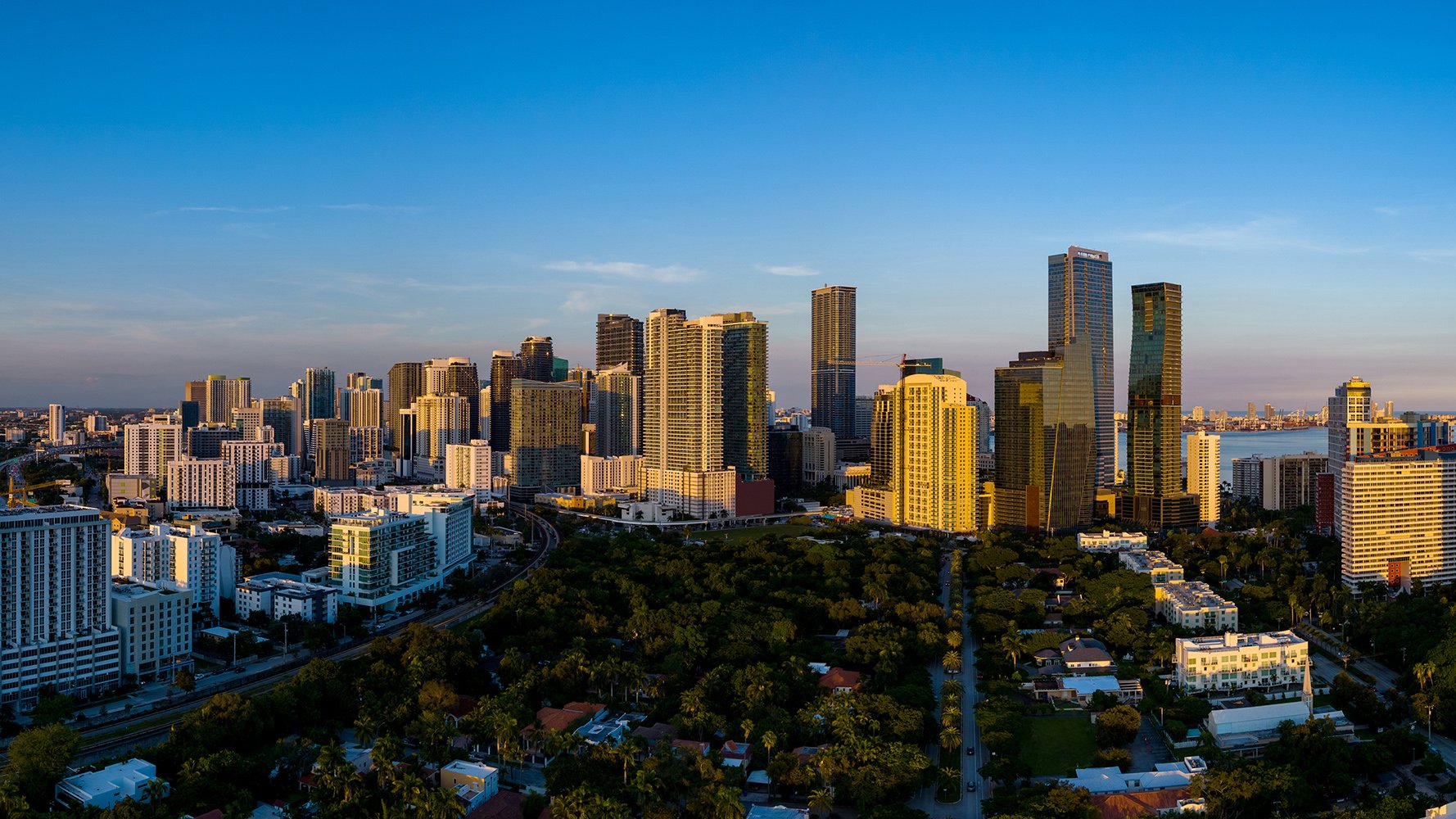 Dusk over Brickell, Miami with pastel sky and high‑rises—waterfront luxury and ultra luxury condos; preconstruction and resale market.