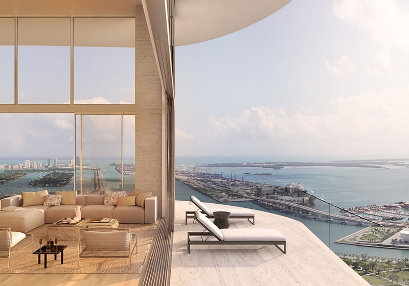 Casa Bella Downtown Miami luxury living room opening to curved balcony loungers with expansive Biscayne Bay views, highlighting ultra luxury preconstruction condos with indoor-outdoor coastal lifestyle.