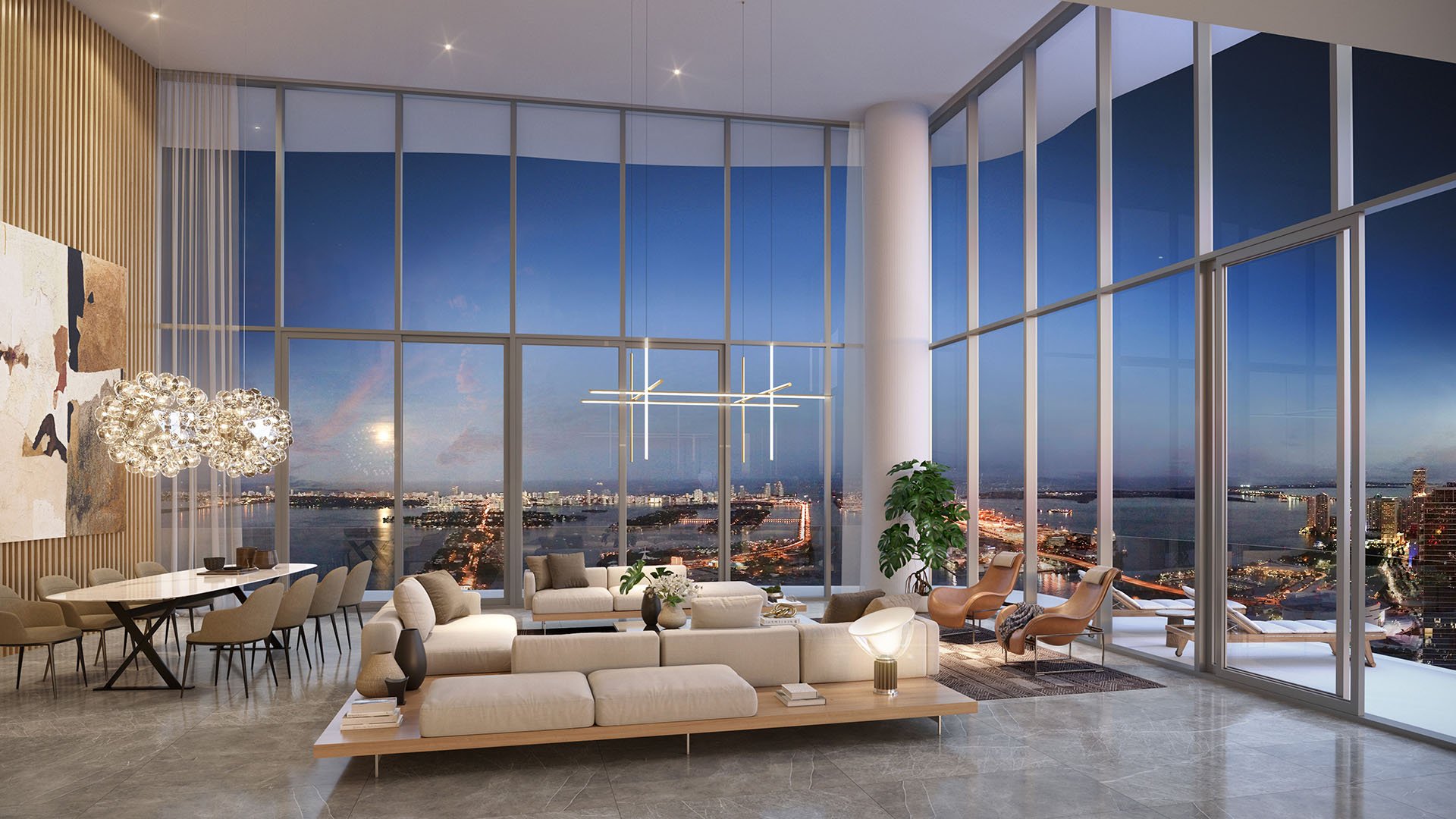 Casa Bella Downtown Miami double-height living room at dusk with floor-to-ceiling glass, Biscayne Bay and city lights, highlighting luxury and ultra luxury preconstruction condos with designer seating and dining area.
