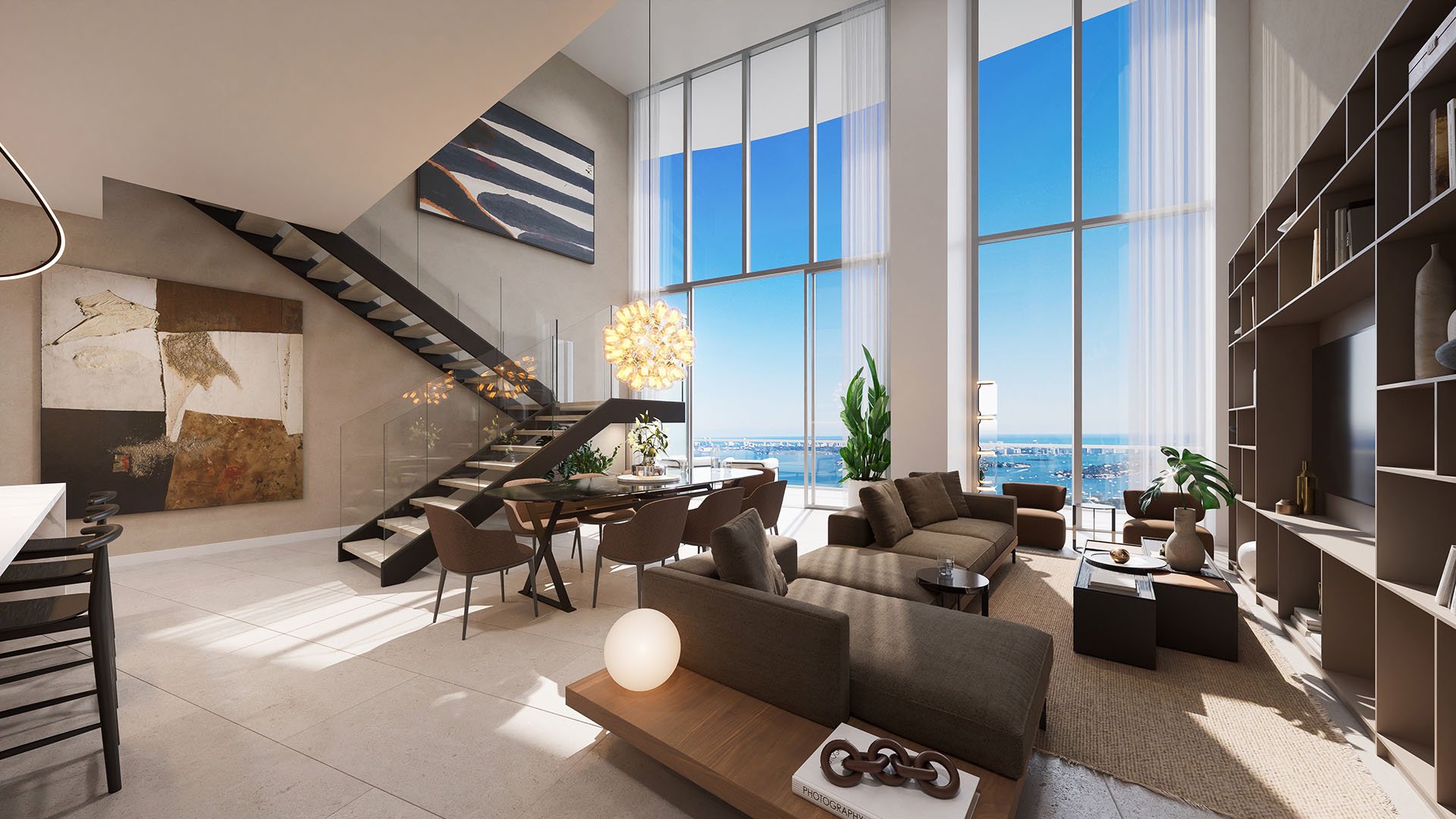 Double-height living room at Casa Bella Downtown Miami in Downtown Miami, FL, with staircase, designer furnishings and panoramic Biscayne Bay views, showcasing luxury and ultra luxury preconstruction condos with expansive glass and open-plan living.