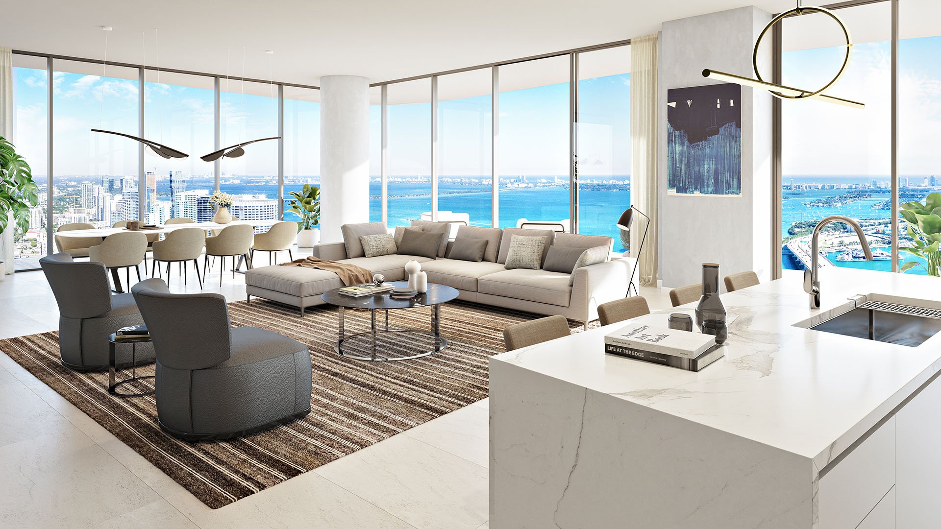 Casa Bella by B&B Italia Downtown Miami open-concept kitchen, dining and living room with marble island and curved glass walls overlooking Biscayne Bay and the ocean, highlighting luxury and ultra luxury preconstruction condos.
