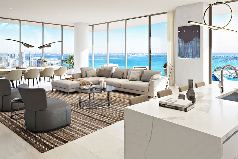 Casa Bella by B&B Italia Downtown Miami open-concept kitchen, dining and living room with marble island and curved glass walls overlooking Biscayne Bay and the ocean, highlighting luxury and ultra luxury preconstruction condos.