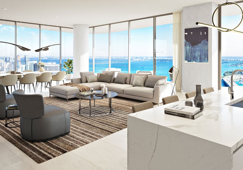 Casa Bella by B&B Italia Downtown Miami open-concept kitchen, dining and living room with marble island and curved glass walls overlooking Biscayne Bay and the ocean, highlighting luxury and ultra luxury preconstruction condos.
