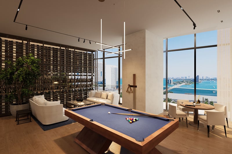 Casa Bella by B&B Italia Downtown Miami game lounge with pool table, wine display wall and seating, set against panoramic Biscayne Bay and skyline views, showcasing luxury and ultra luxury preconstruction condos amenities.