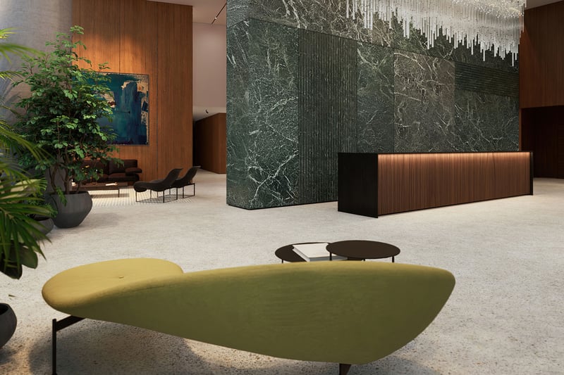 Casa Bella by B&B Italia Downtown Miami grand lobby with marble feature wall, concierge desk, statement chandelier and lush greenery, showcasing luxury and ultra luxury preconstruction condos arrival experience.