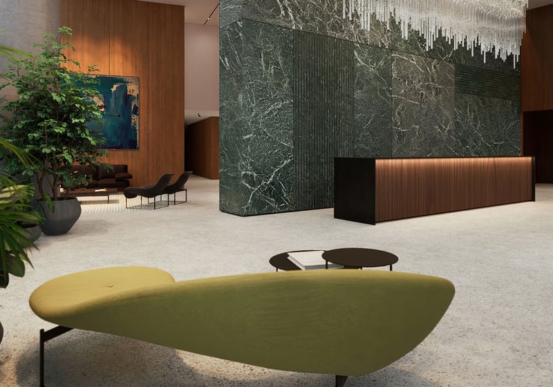 Casa Bella by B&B Italia Downtown Miami grand lobby with marble feature wall, concierge desk, statement chandelier and lush greenery, showcasing luxury and ultra luxury preconstruction condos arrival experience.