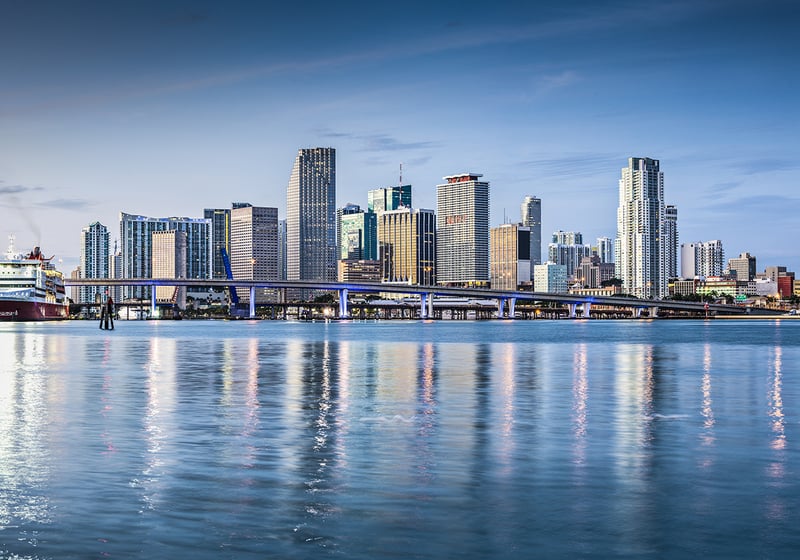 Miami waterfront cityscape at sunset; luxury and ultra luxury condos along the bay, preconstruction options across Miami’s prime districts.