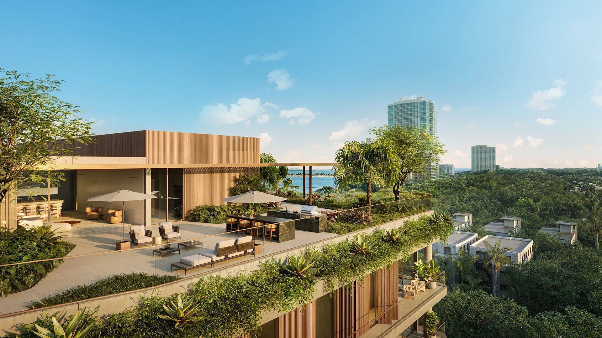 Colette Residences in Brickell luxury ultra luxury condos with a rooftop lounge terrace, outdoor kitchen, shaded seating, lush landscaping, and a water view beyond the treetops.