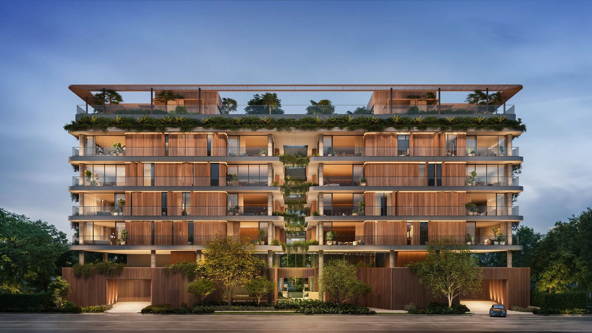 Colette Residences in Brickell luxury ultra luxury condos with a symmetrical front elevation at dusk, glowing interiors, layered greenery, and expansive terraces.