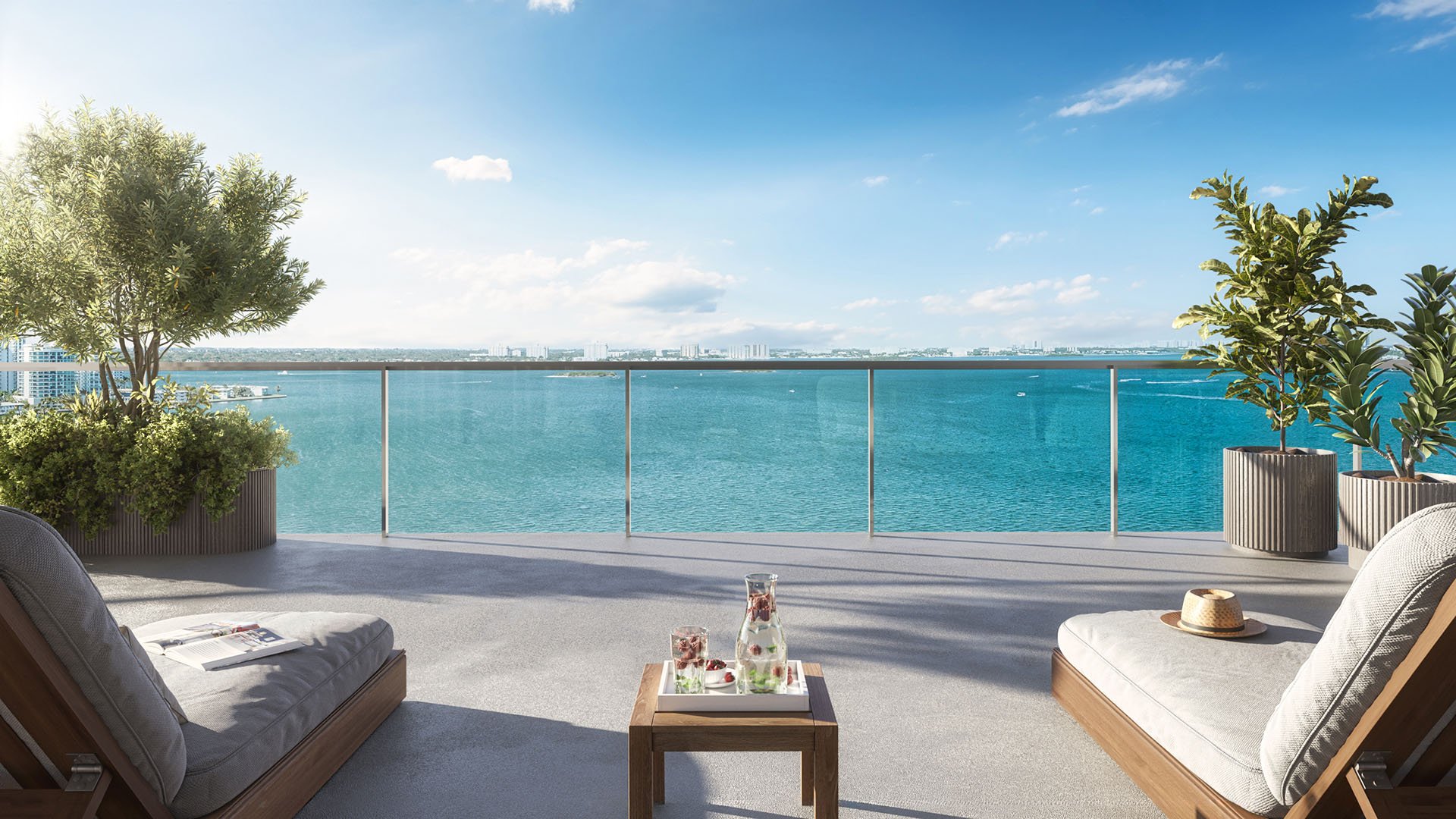 Bayfront terrace with chaise loungers, glass railing, and open water views at Continuum Club and Residences in North Bay Village, a preconstruction luxury and ultra luxury condos development with expansive outdoor living space.