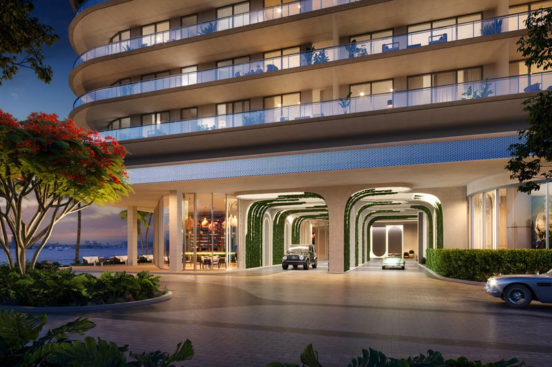 Curved porte cochere entrance with illuminated canopy arches and lush landscaping at Continuum Club and Residences in North Bay Village, a preconstruction luxury and ultra luxury condos development on the waterfront.