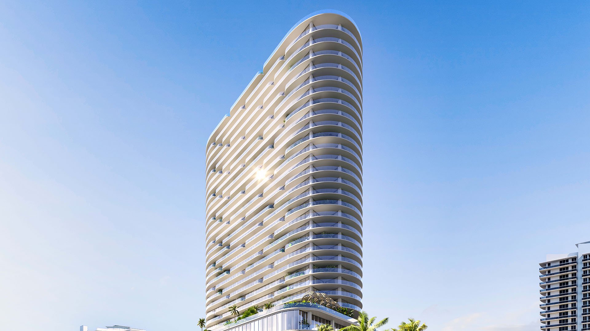 Skyward exterior view of the curved condo tower at Continuum Club and Residences in North Bay Village, a preconstruction luxury and ultra luxury condos development with sweeping balconies rising against a clear blue sky.