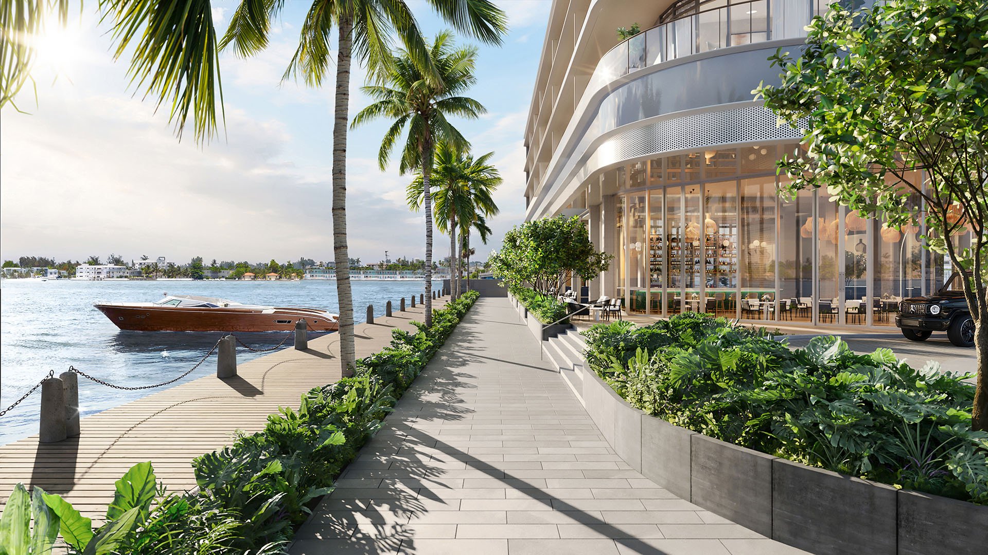 Waterfront promenade with lush landscaping, boat dock access, and the tower facade at Continuum Club and Residences in North Bay Village, a preconstruction luxury and ultra luxury condos development along the bay.