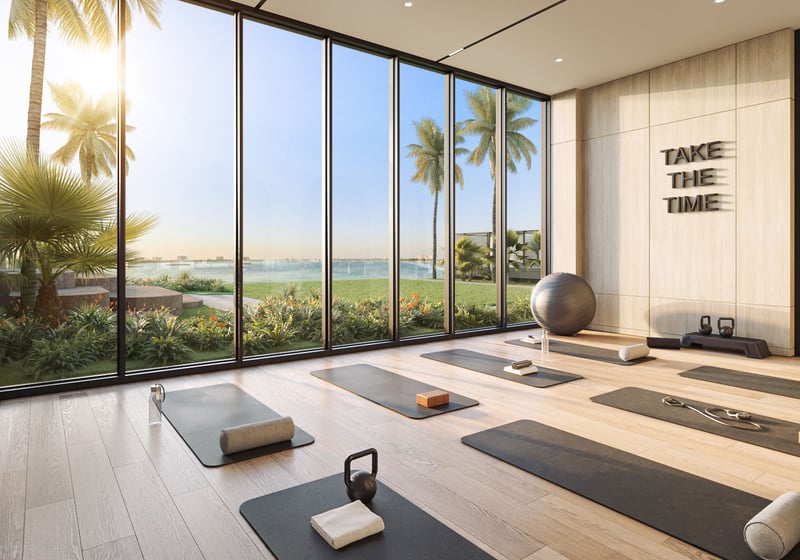 Yoga studio with mats, floor-to-ceiling glass, and garden views at Continuum Club and Residences in North Bay Village, a preconstruction luxury and ultra luxury condos development with serene waterfront wellness amenities.