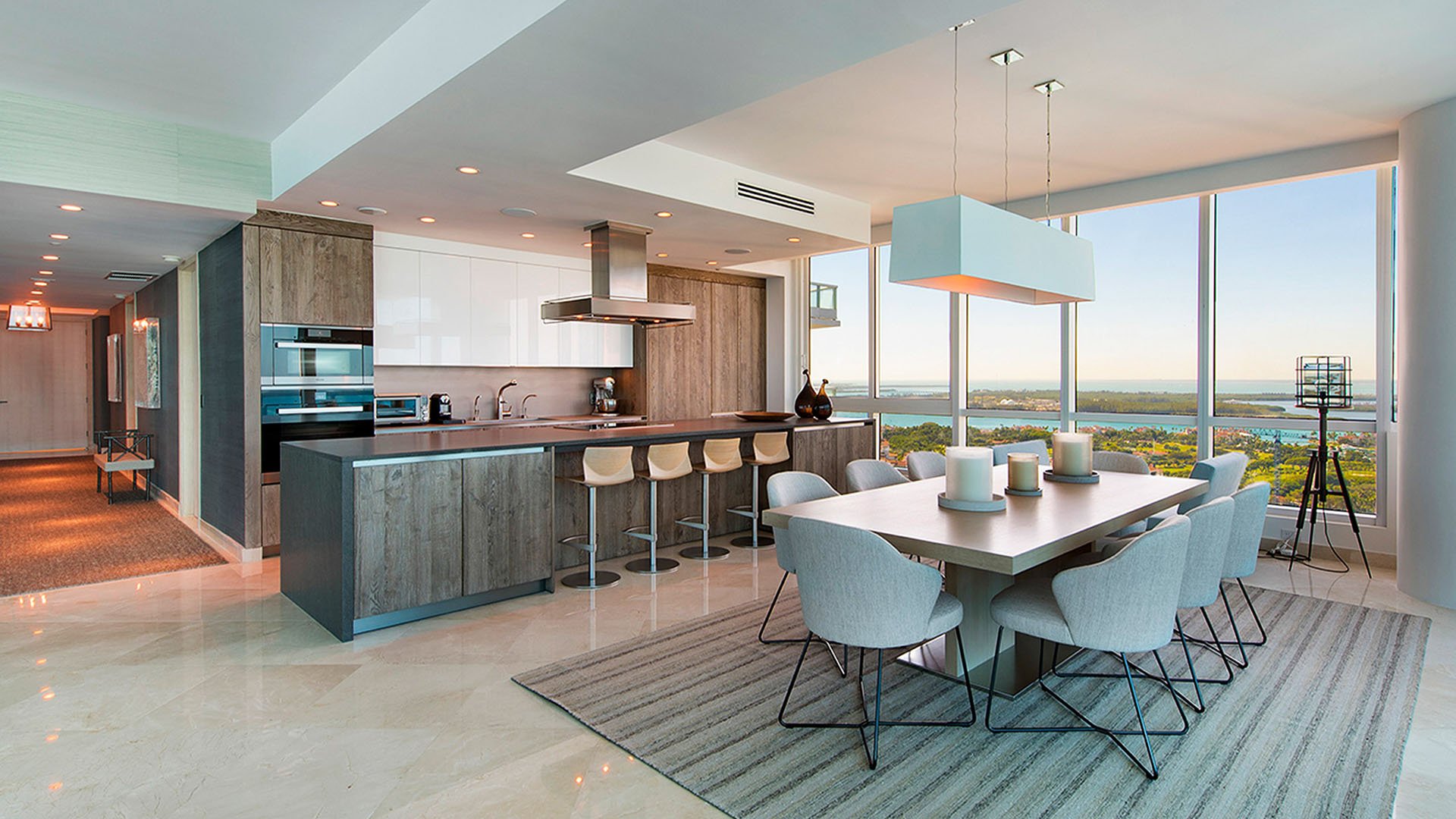 Open kitchen and dining area at Continuum on South Beach, Miami Beach, Florida, for luxury and ultra luxury condos, featuring bar seating, clean modern cabinetry, and expansive water views.