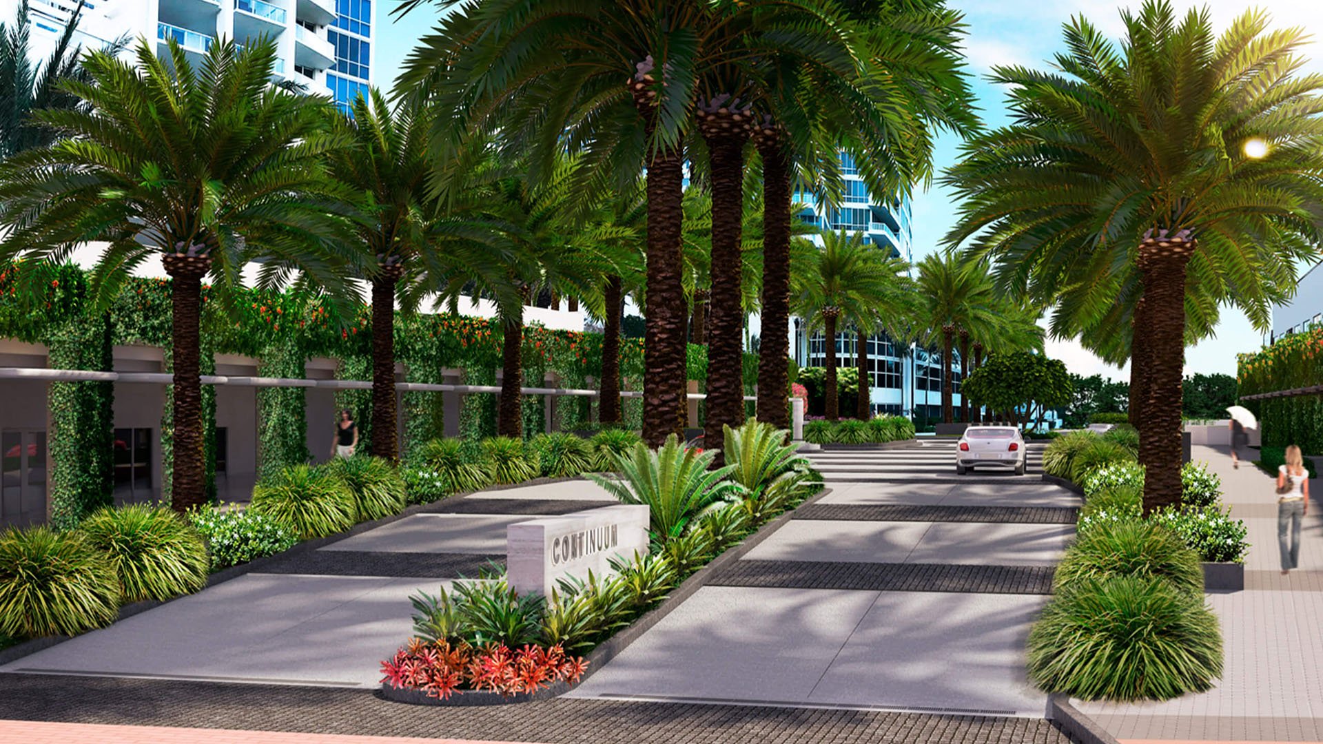 Palm-lined arrival drive at Continuum on South Beach, Miami Beach, Florida, leading into luxury and ultra luxury condos with lush landscaping, a landscaped median, and tower facades beyond.