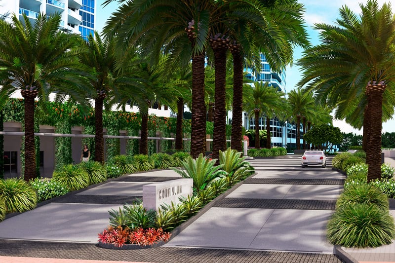 Palm-lined arrival drive at Continuum on South Beach, Miami Beach, Florida, leading into luxury and ultra luxury condos with lush landscaping, a landscaped median, and tower facades beyond.