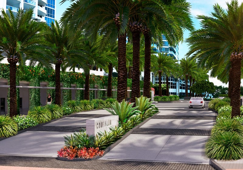 Palm-lined arrival drive at Continuum on South Beach, Miami Beach, Florida, leading into luxury and ultra luxury condos with lush landscaping, a landscaped median, and tower facades beyond.