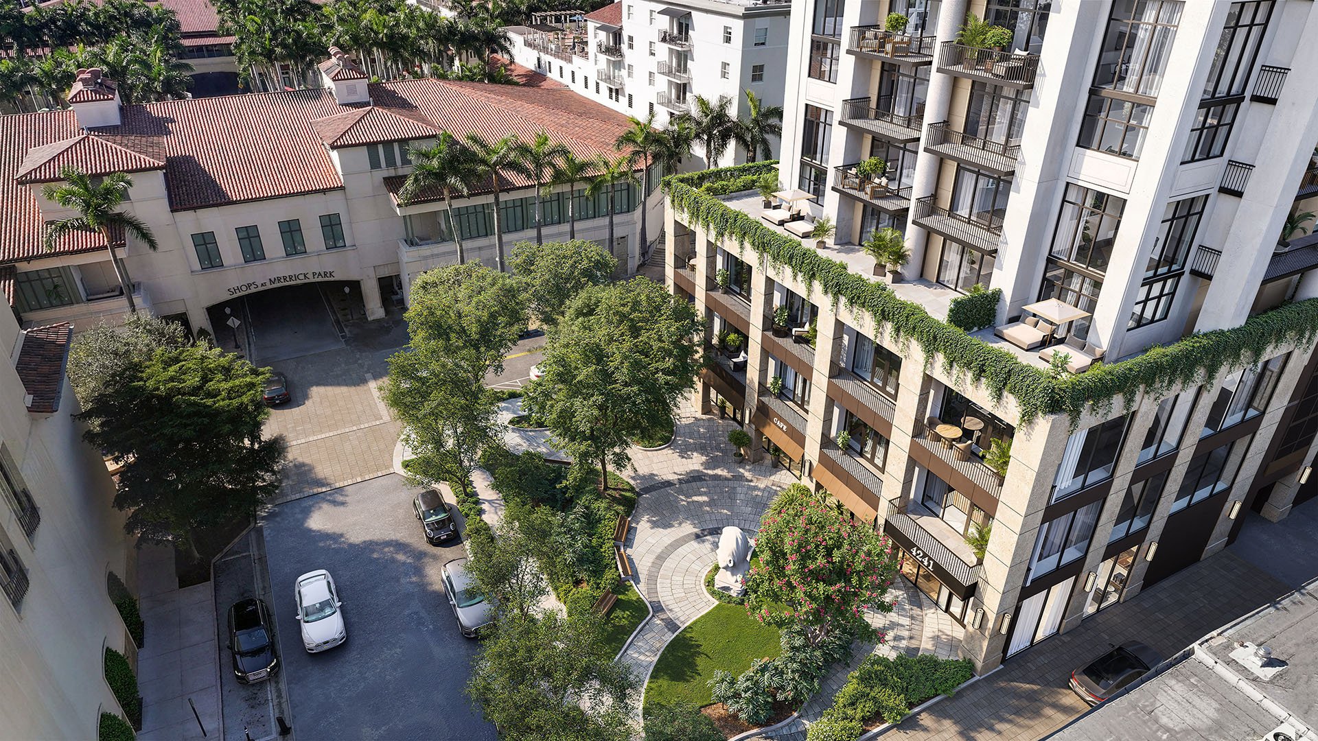Aerial view of the landscaped courtyard, circular garden, and terraced condo facade at Cora Merrick Park in Coral Gables, highlighting luxury and ultra luxury condos with lush terraces and a pedestrian-focused arrival experience.