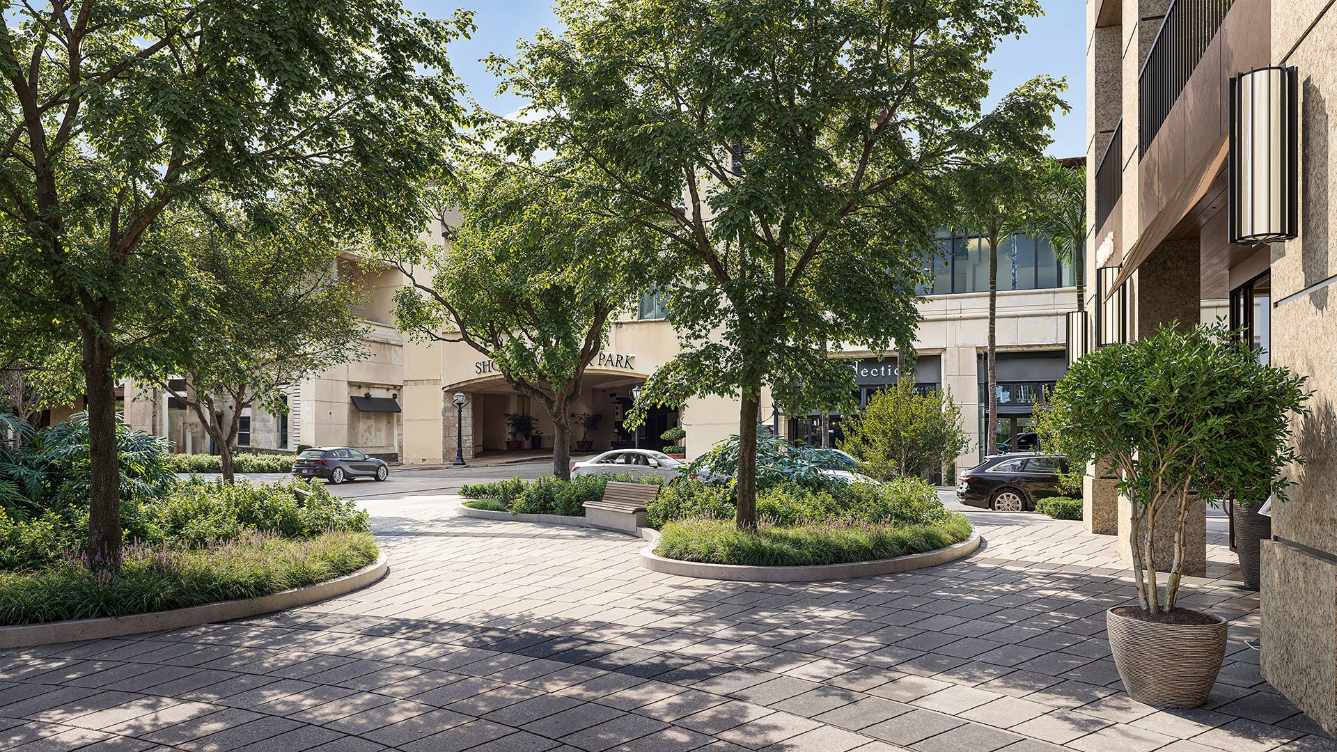 Landscaped motor court and paved arrival entry at Cora Merrick Park in Coral Gables, framed by mature trees and layered planting for luxury and ultra luxury condos.