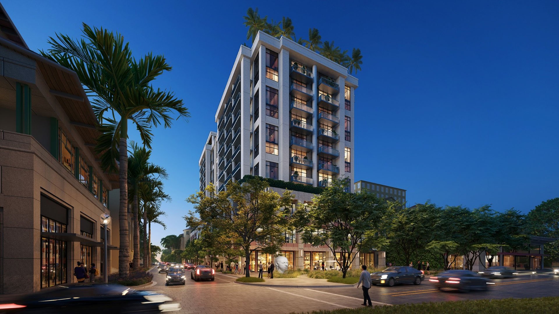 Nighttime street view of Cora Merrick Park in Coral Gables featuring the illuminated condo tower, palm-lined avenue, and active ground-floor retail for luxury and ultra luxury condos.