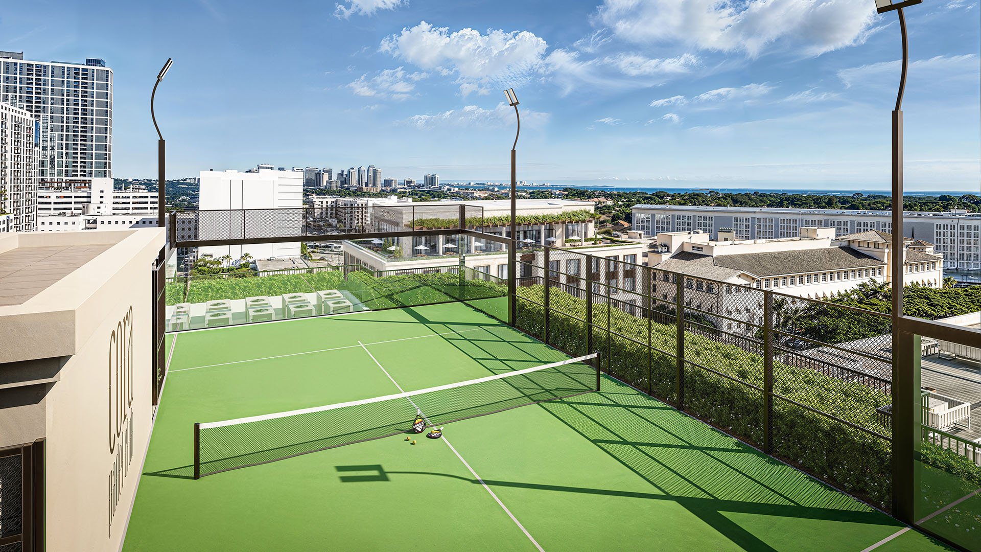 Rooftop padel court at Cora Merrick Park in Coral Gables with skyline and water views across the horizon, created for luxury and ultra luxury condos.