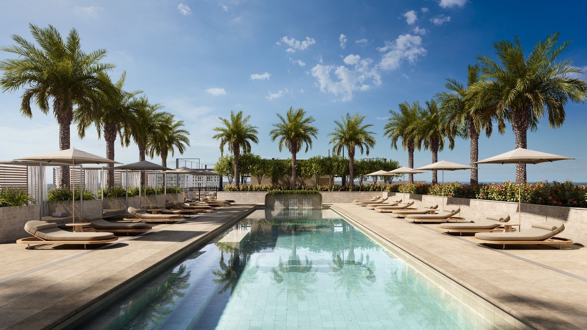 Rooftop pool terrace lined with palms, loungers, and umbrellas at Cora Merrick Park in Coral Gables, a signature retreat for luxury and ultra luxury condos.