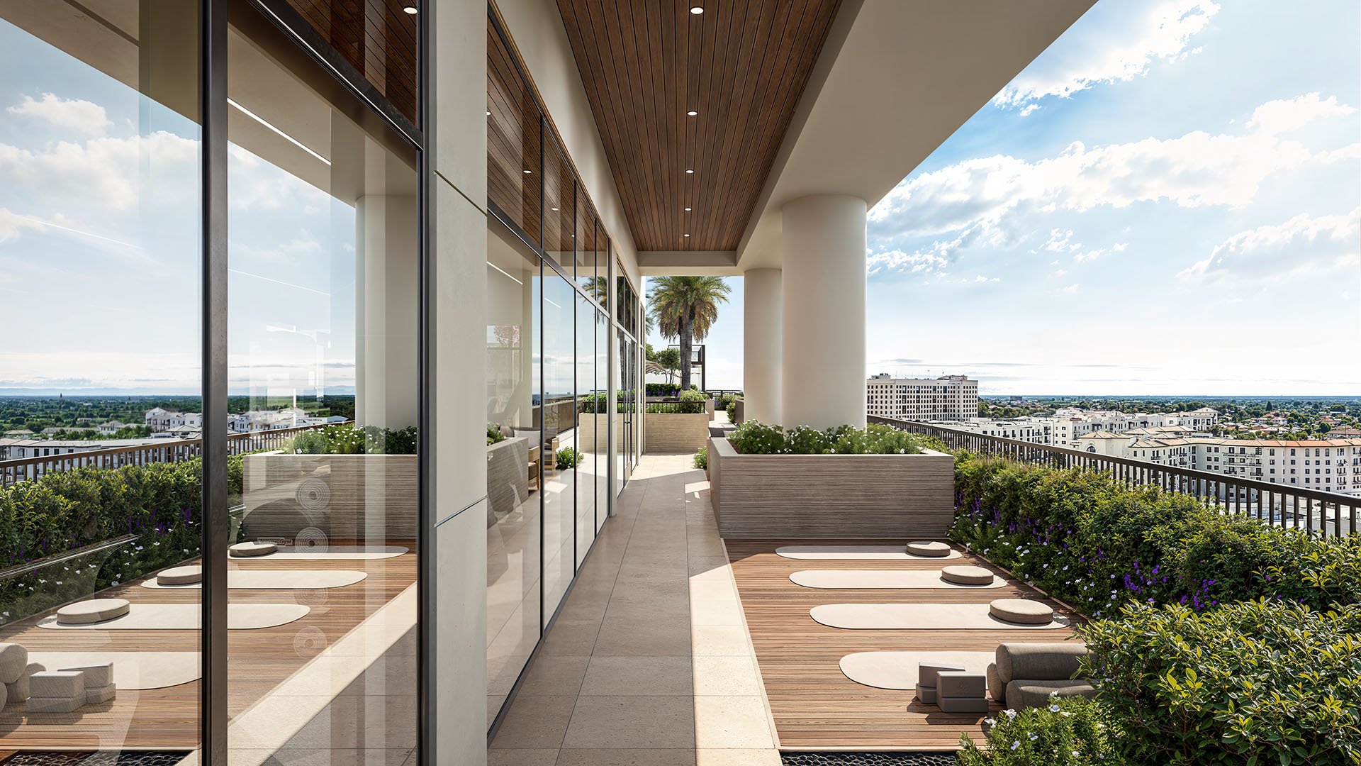 Rooftop yoga terrace with meditation pads, wood decking, and expansive skyline views at Cora Merrick Park in Coral Gables for luxury and ultra luxury condos.