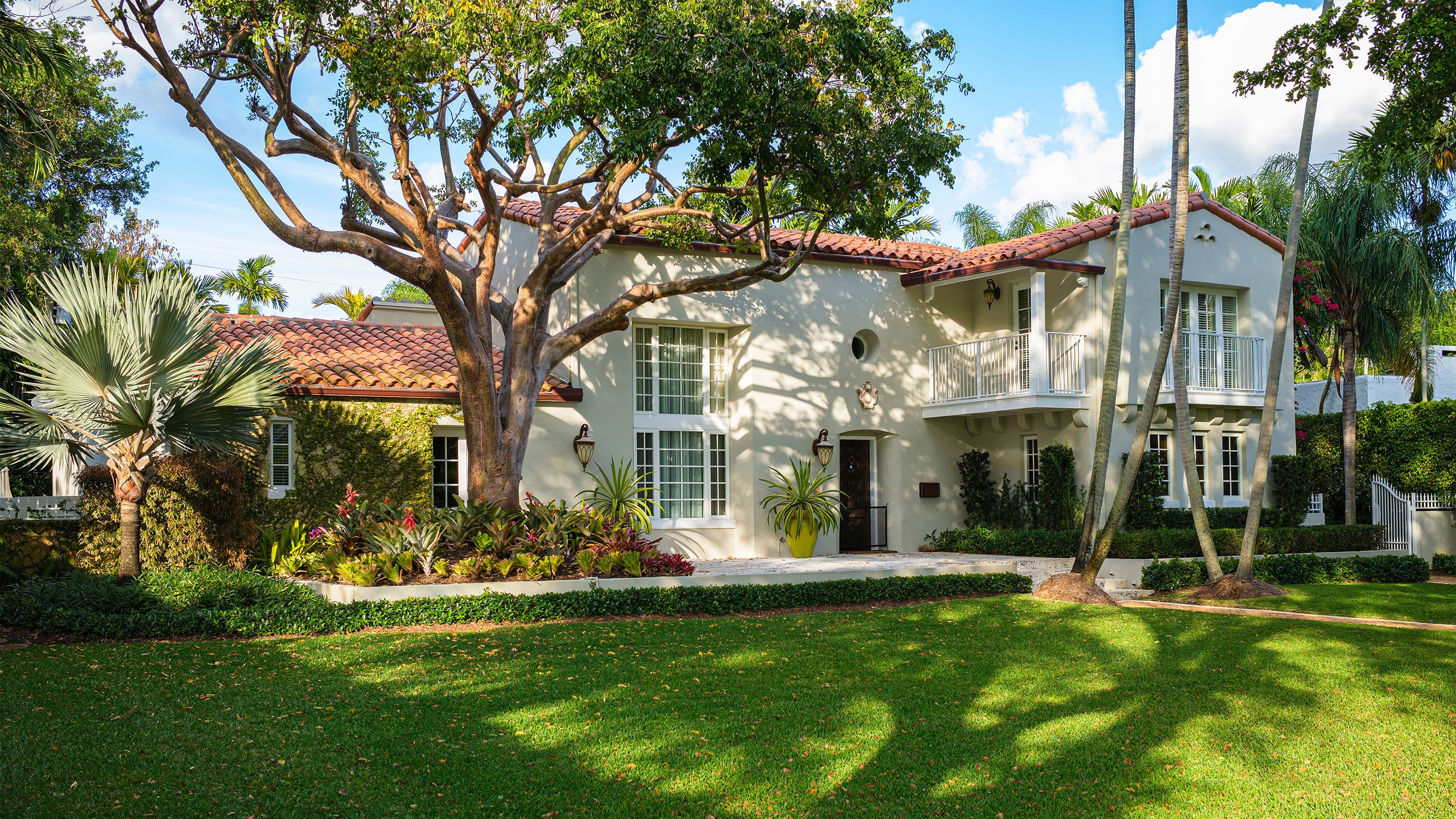 Lush tropical residence in Coral Gables framed by palms—prestige neighborhood close to luxury and ultra luxury condos; preconstruction and resale.