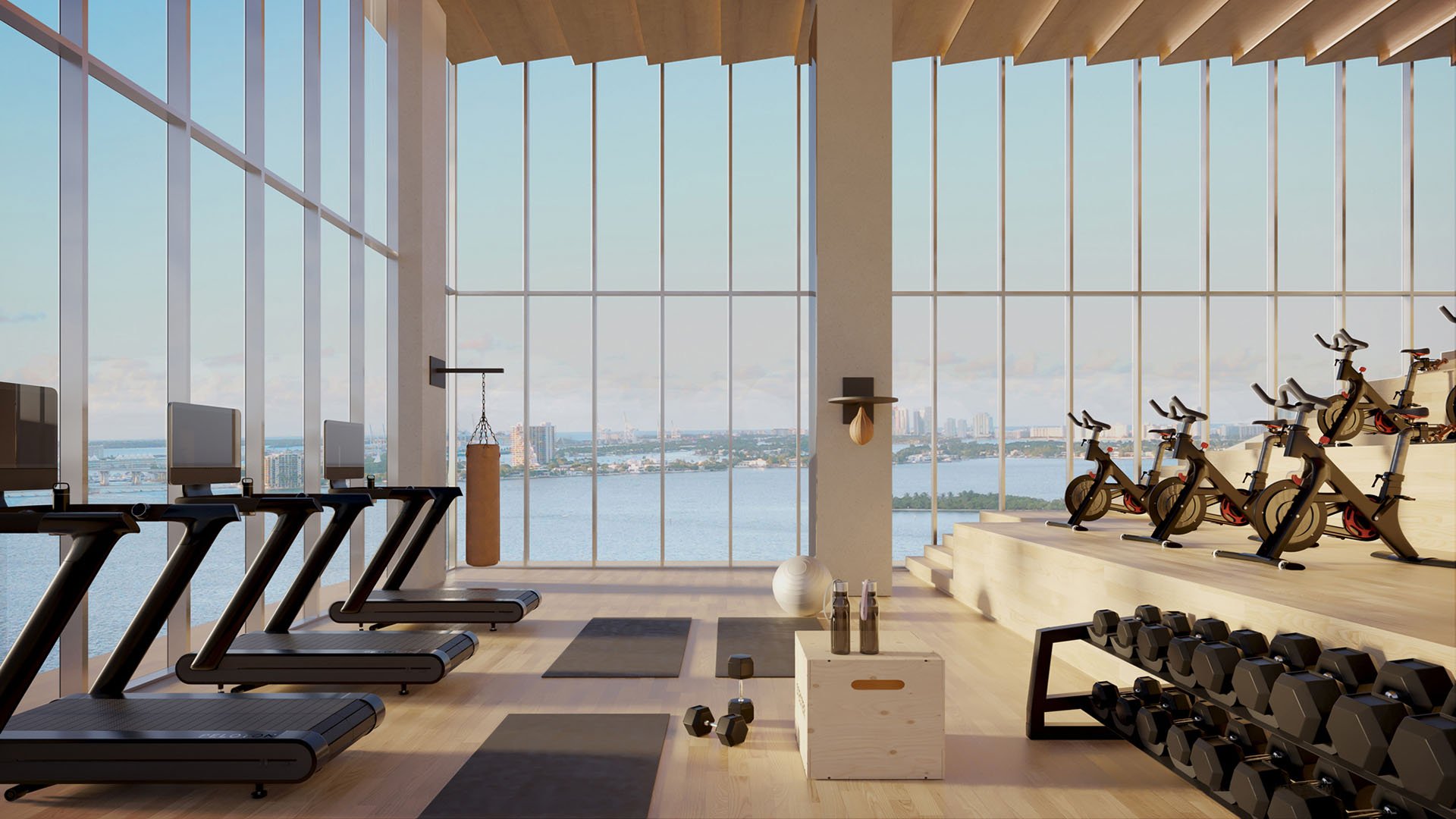 Cove Miami in Miami presents luxury and ultra luxury condos in preconstruction, featuring a fitness center with treadmills, spin bikes, free weights, and full-height windows facing the bay.