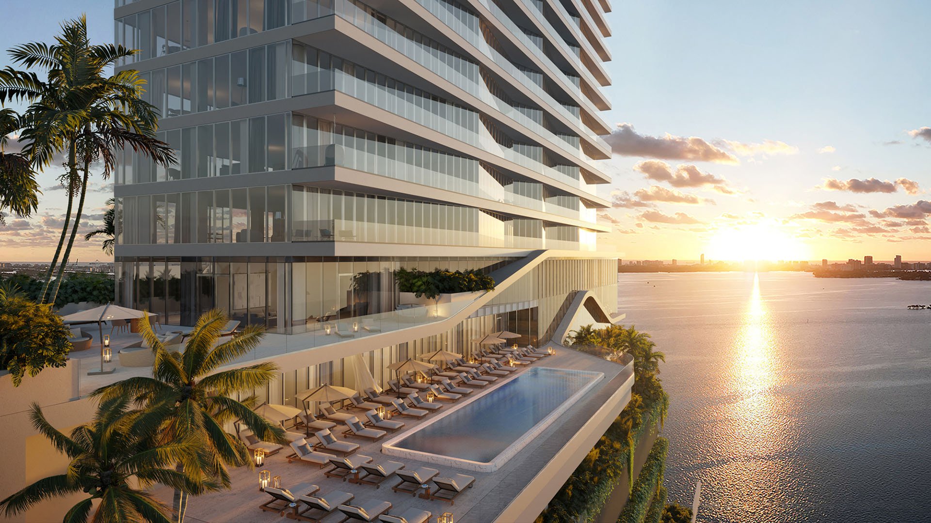 Cove Miami in Miami presents luxury and ultra luxury condos in preconstruction, featuring an elevated pool deck along the tower at sunset, with loungers, palms, and a waterfront backdrop.