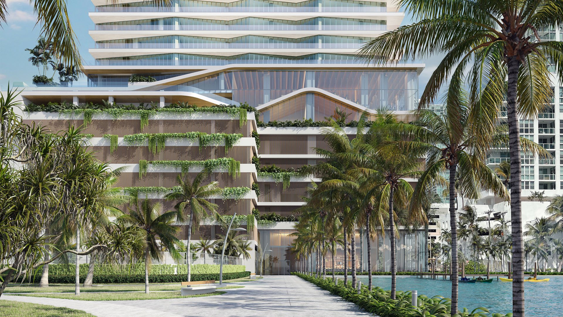 Cove Miami in Miami presents luxury and ultra luxury condos in preconstruction, featuring a palm-lined waterfront boardwalk leading to a terraced condo podium with lush landscaping and curved balcony lines.