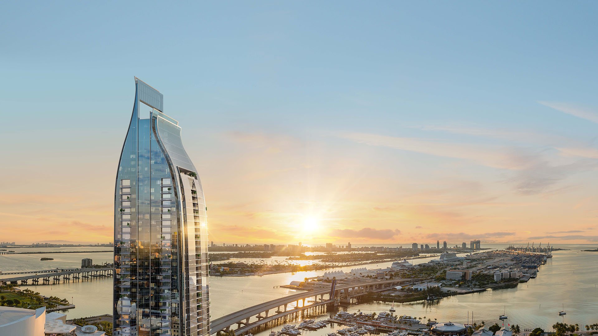 Curved glass tower exterior at Delano Residences & Hotel, Miami, rising above the waterfront at sunrise with bridge and bay views, showing luxury and ultra luxury preconstruction condos.