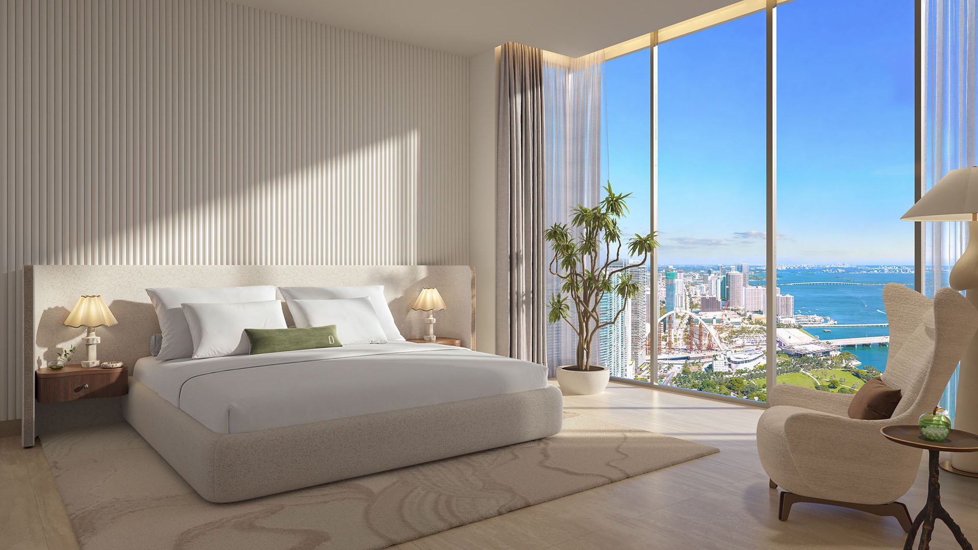 Primary bedroom at Delano Residences & Hotel, Miami, with floor-to-ceiling corner windows, a sitting area, and broad bay and skyline views, showing luxury and ultra luxury preconstruction condos.