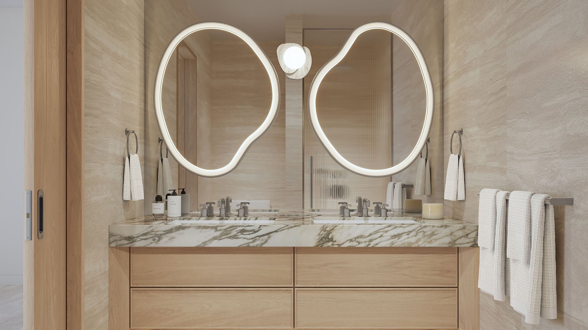Primary bathroom at Delano Residences & Hotel, Miami, with a double vanity, marble countertop, sculptural backlit mirrors, and warm stone finishes, showing luxury and ultra luxury preconstruction condos.