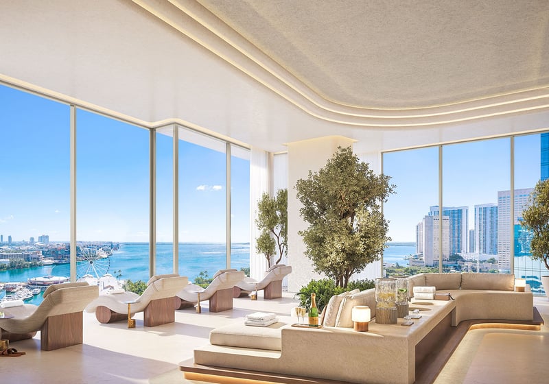 Spa lounge at Delano Residences & Hotel, Miami, with chaise seating, indoor trees, floor-to-ceiling windows, and waterfront views, showing luxury and ultra luxury preconstruction condos.