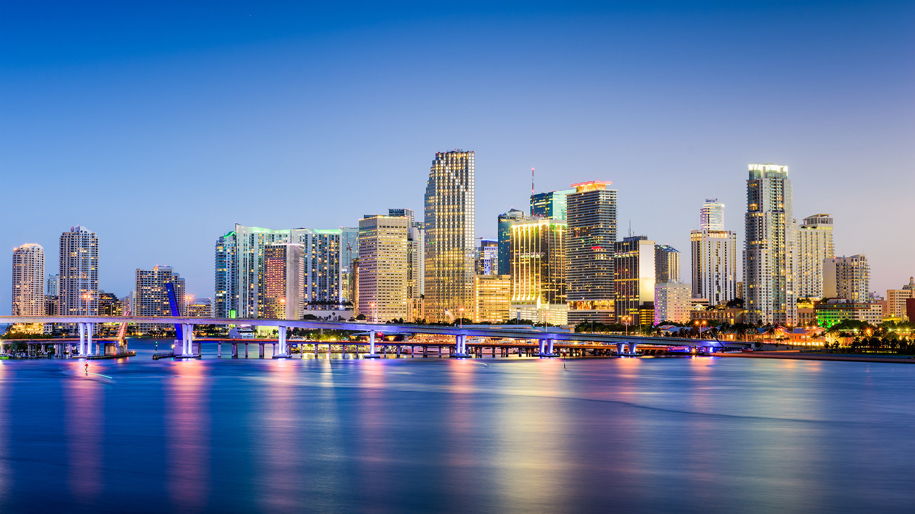 Downtown Miami skyline at dusk featuring luxury urban high-rise condos, preconstruction residential projects and waterfront city views ideal for ultra luxury living