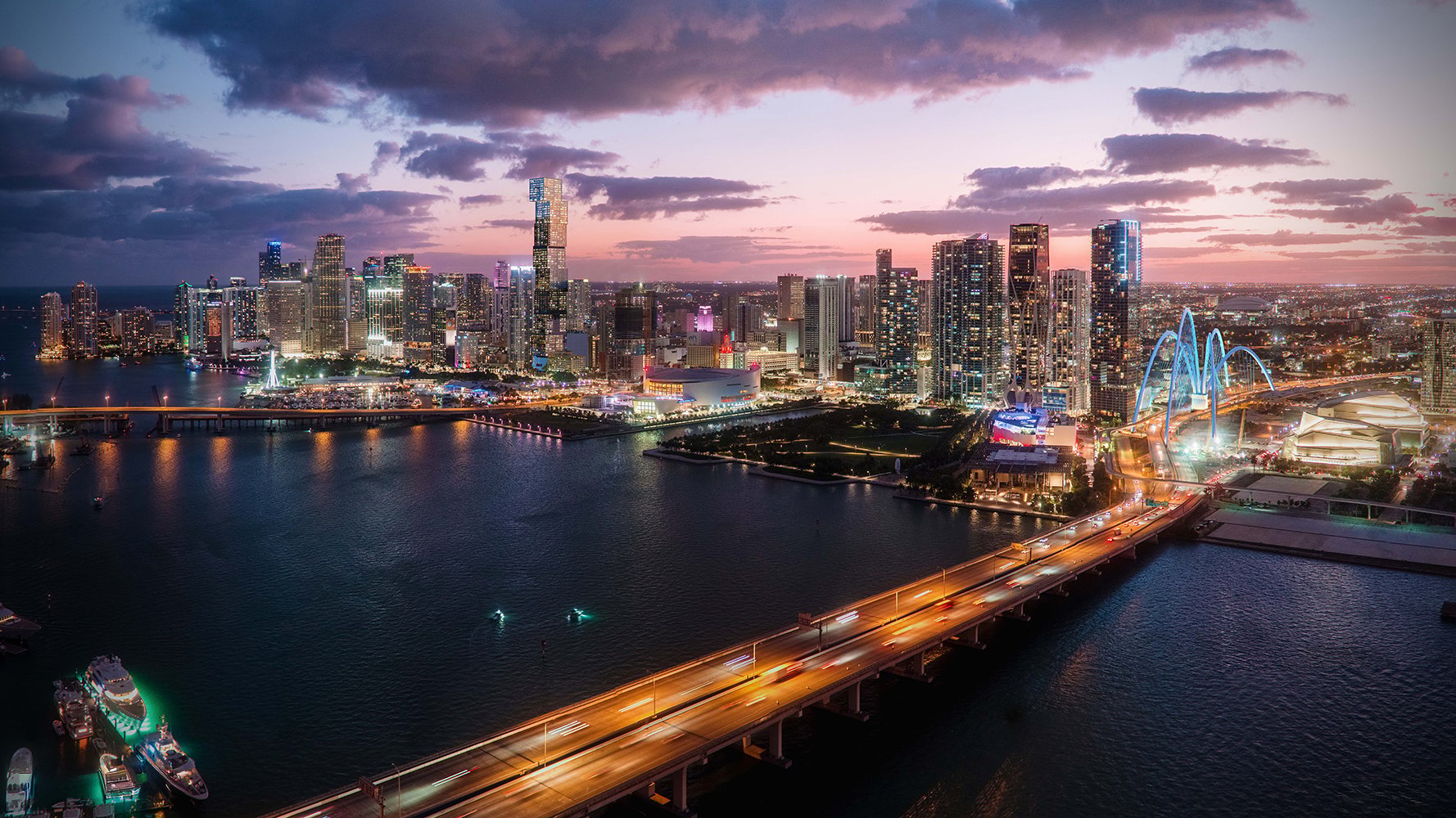Downtown Miami skyline at dusk with luxury condo towers, Biscayne Bay view, and illuminated city waterfront.