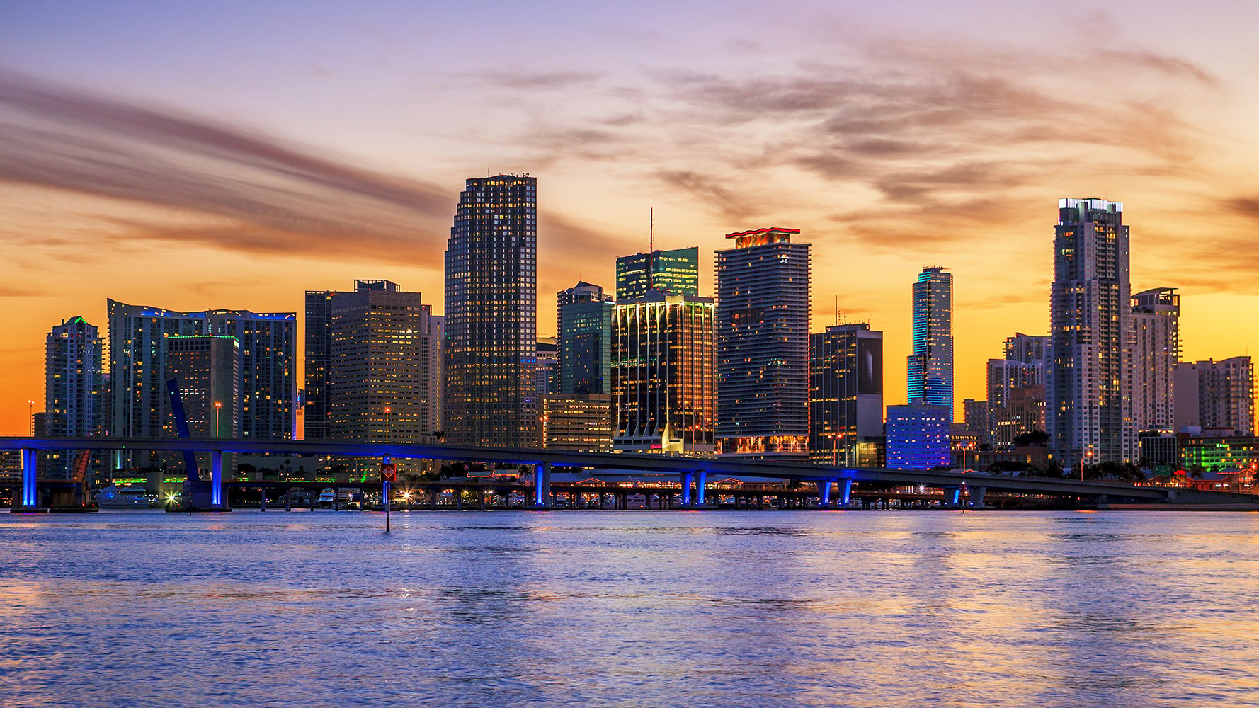 Downtown Miami sunset skyline over the marina and Biscayne Bay, prestigious setting for luxury and ultra luxury condos, with active preconstruction and resale.