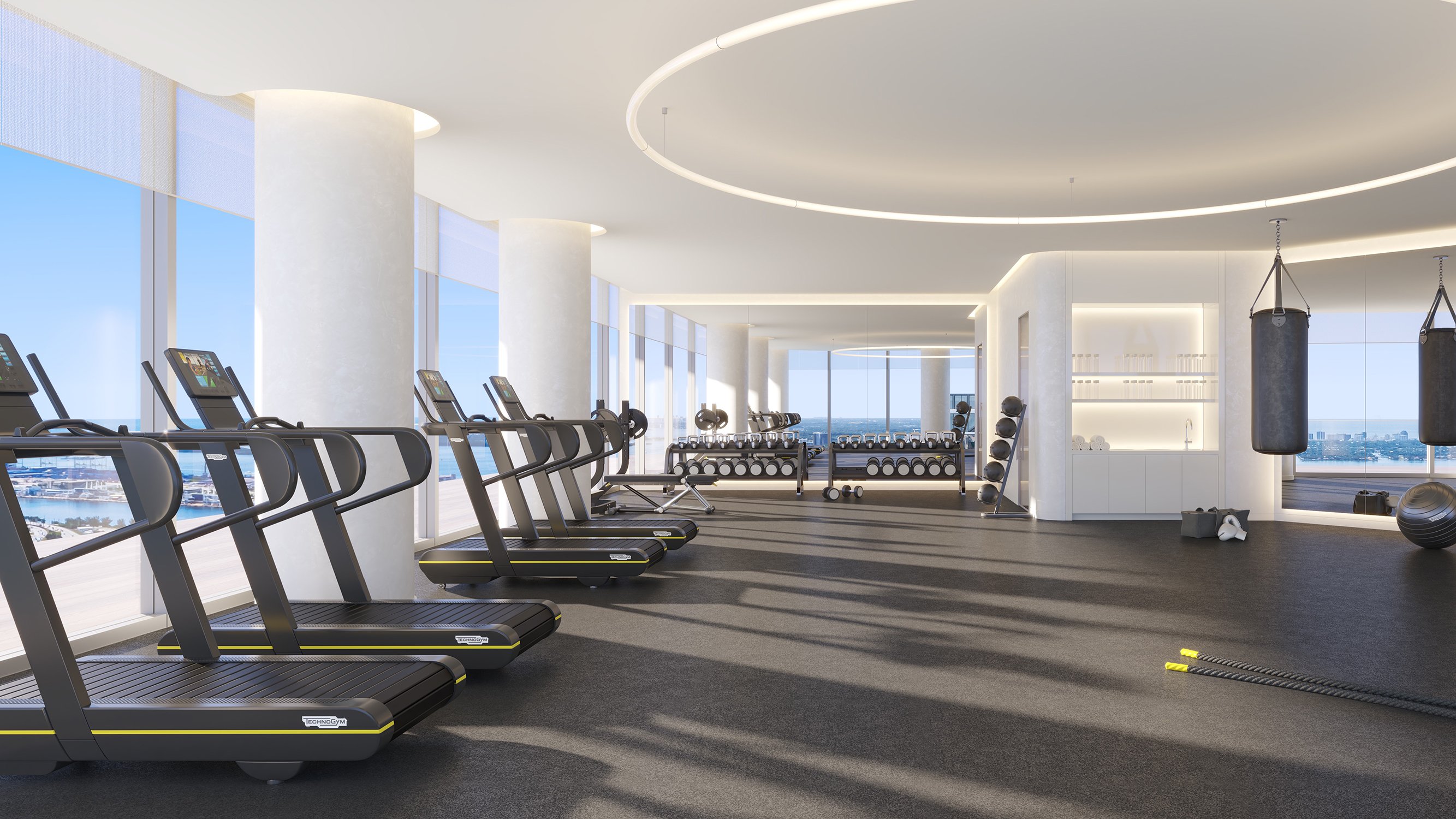 Edition Edgewater, Miami light‑filled gym facing Biscayne Bay, wellness amenity for luxury and ultra luxury condos; preconstruction in Edgewater. Featuring modern interior and scenery.