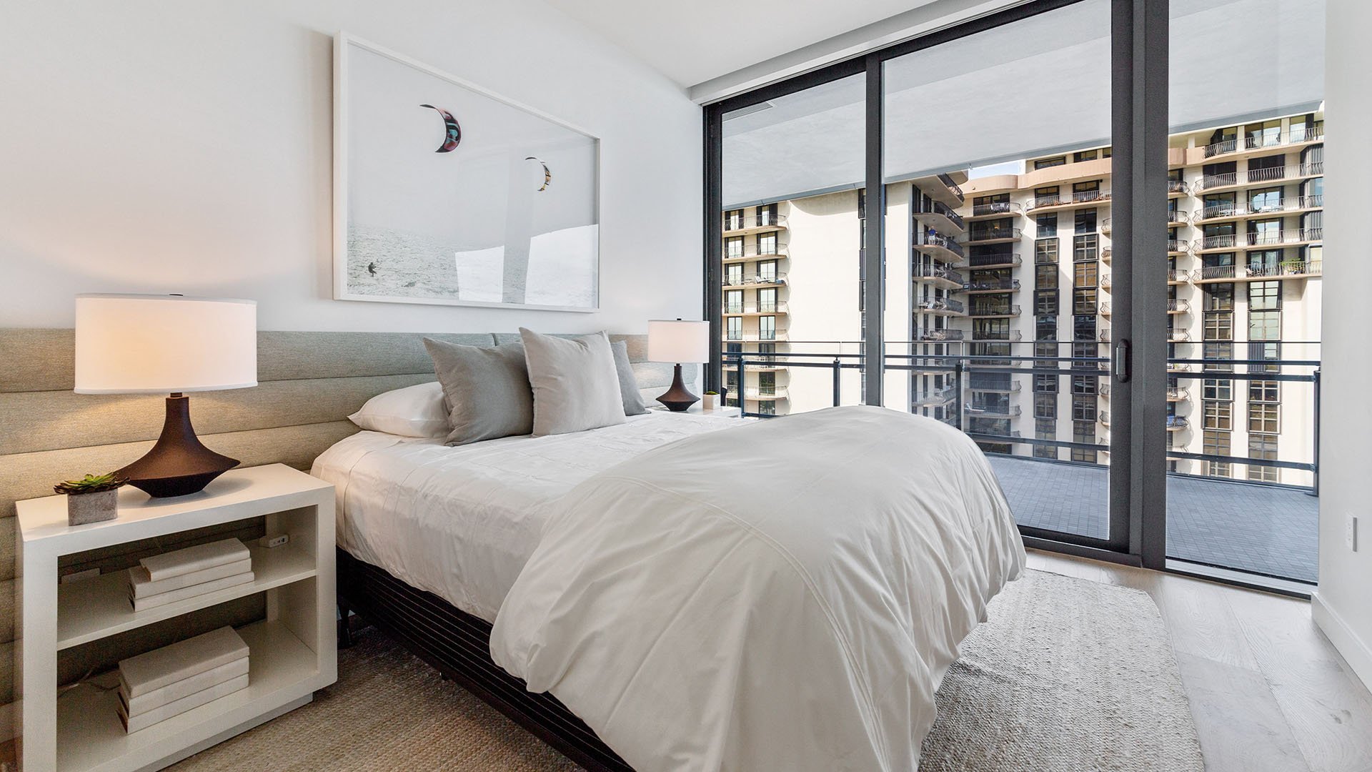 Eighty Seven Park, Miami Beach luxury and ultra luxury condos bedroom with soft neutral finishes, a private balcony, and views toward neighboring high-rise residences.