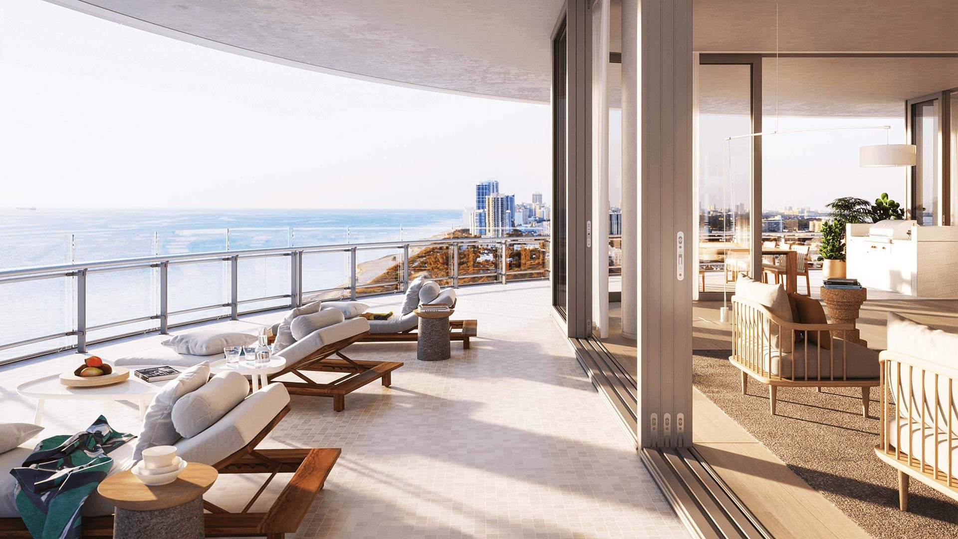 Eighty Seven Park, Miami Beach luxury and ultra luxury condos wraparound terrace lounge with chaise seating, open-air living space, and panoramic ocean and coastline views.